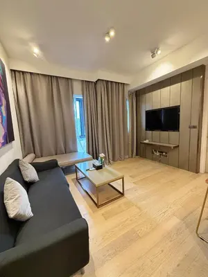 a living room with a black couch and a television at Star Residence klcc by Aqua in Kuala Lumpur