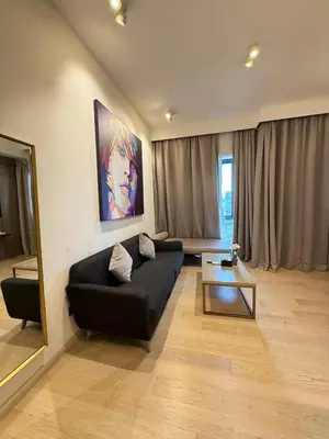 a living room with a black couch and a table at Star Residence klcc by Aqua in Kuala Lumpur