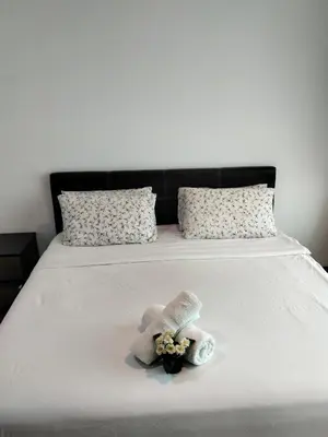 a bed with a stuffed animal and flowers on it at Vortex suites Klcc near KL in Kuala Lumpur