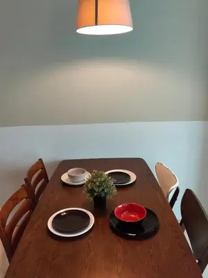 a wooden table with plates and a vase of flowers on it at Vortex suites Klcc near KL in Kuala Lumpur