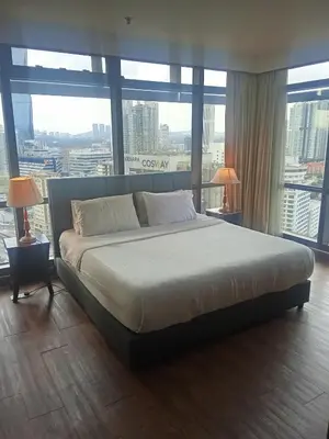a large bed in a room with large windows at Times square Suites at Time Square KL in Kuala Lumpur