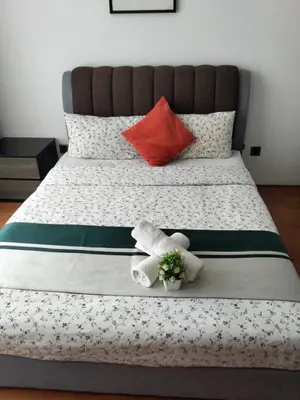 a bedroom with a bed with towels and a red pillow at Vortex suites Klcc near KL Area in Kuala Lumpur
