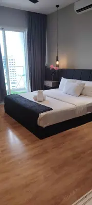 a large bed in a bedroom with a large window at Sky Suites at Quill Residence Kuala Lumpur in Kuala Lumpur