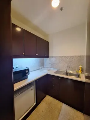 a kitchen with brown cabinets and a sink at Suite at Bukit Bintang in Kuala Lumpur