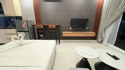 a room with a bed and a tv and a table at Majestic Sky Deck Suites in Kuala Lumpur