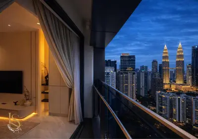 a balcony with a view of the city at night at LUXURA SUITE's E A T O N KLCC in Kuala Lumpur