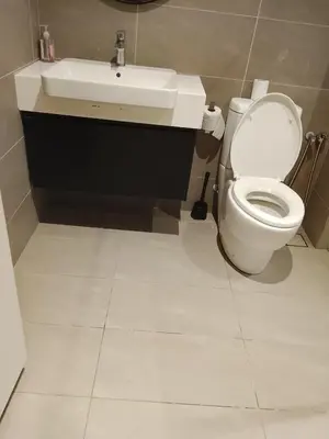 a bathroom with a white toilet and a sink at Quill Luxury Suites KLCC in Kuala Lumpur