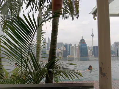 a couple of people swimming in the water in the city at Female Hostel Regalia Residence in Kuala Lumpur