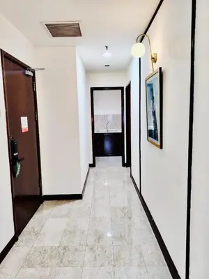 a hallway with white walls and a tile floor at Times Square Service Apartment KL in Kuala Lumpur