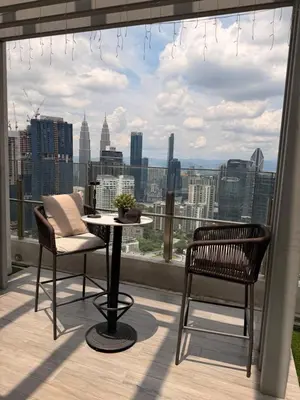 a balcony with a table and chairs and a view of the city at Agile Family Suites -TRX Kualalampur in Kuala Lumpur