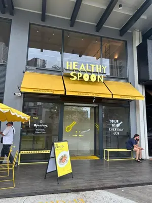 a restaurant with a yellow awning in front of a building at Agile Family Suites -TRX Kualalampur in Kuala Lumpur