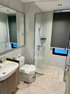 a bathroom with a shower and a toilet and a sink at Agile Family Suites -TRX Kualalampur in Kuala Lumpur