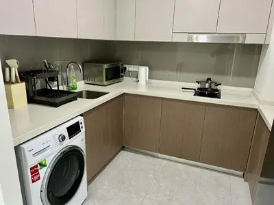 a kitchen with a washing machine and a microwave at Agile Family Suites -TRX Kualalampur in Kuala Lumpur