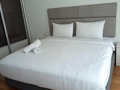 a white bed with a teddy bear sitting on it at Vortex Amira suites klcc Apartment in Kuala Lumpur