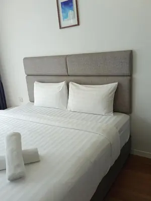 a large bed with white sheets and pillows at Vortex Amira suites klcc Apartment in Kuala Lumpur