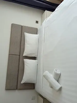 a room with a bed with white pillows at Vortex Amira suites klcc Apartment in Kuala Lumpur