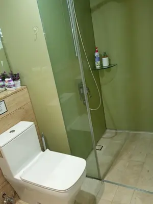 a bathroom with a toilet and a glass shower at Vortex Amira suites klcc Apartment in Kuala Lumpur