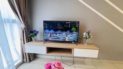 a television sitting on a stand in a living room at The Grand Suites - Trion KL in Kuala Lumpur
