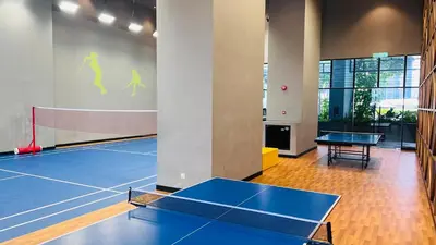 a room with a tennis court with two tables at The Grand Suites - Trion KL in Kuala Lumpur