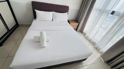 a bed with two towels on it in a room at The Grand Suites - Trion KL in Kuala Lumpur