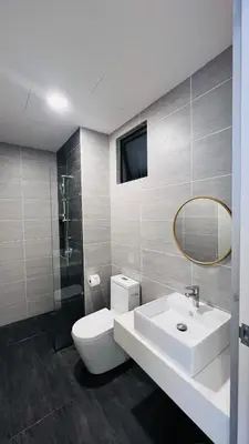 a bathroom with a sink and a toilet and a mirror at The Grand Suites - Trion KL in Kuala Lumpur