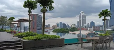 a patio with tables and chairs and a view of a city at Opus Residence KL118 By Millennium Suite in Kuala Lumpur