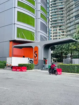 a motorcycle parked in a parking lot in front of a building at Axora Sky Suites KLCC in Kuala Lumpur