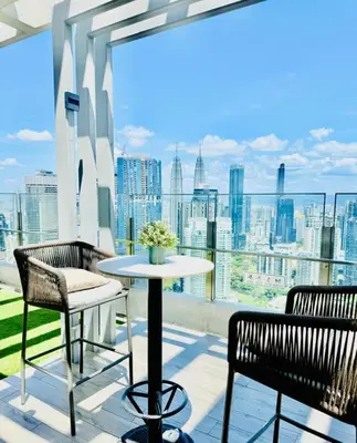 a table and chairs on a balcony with a view of the city at Agile Residence Kuala Lumpur Bukit Bintang in Kuala Lumpur