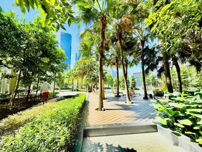 a man walking down a sidewalk in a park with palm trees at Agile Residence Kuala Lumpur Bukit Bintang in Kuala Lumpur