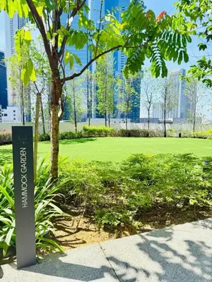 a sign in a park with a tree and buildings at Agile Residence Kuala Lumpur Bukit Bintang in Kuala Lumpur