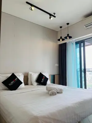 a bedroom with a large white bed with black pillows at STAR Hotel Apartment in Kuala Lumpur