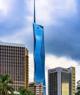 a tall blue building in front of some buildings at STAR Hotel Apartment in Kuala Lumpur