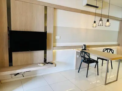 a room with a table and a television and a chair at STAR Hotel Apartment in Kuala Lumpur