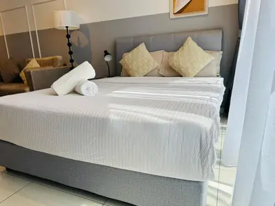 a bed with white sheets and pillows in a room at Majestic Suites klcc By EQ in Kuala Lumpur