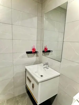 a white bathroom with a sink and a mirror at Grand Suites KLCC By Majestic Residence in Kuala Lumpur