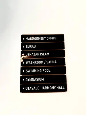 a stack of black signs on a wall at Grand Suites KLCC By Majestic Residence in Kuala Lumpur