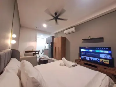 a living room with a bed and a flat screen tv at Grand Suites KLCC By Majestic Residence in Kuala Lumpur