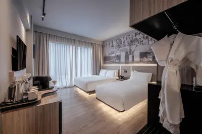 a hotel room with a bedroom with a bed and a tv at The Kuala Lumpur Journal Hotel in Kuala Lumpur