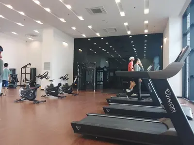 a gym with treadmills and people in the gym at Chamber Klcc Suites Luxury Home in Kuala Lumpur