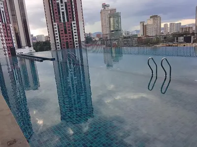 a pool of water with a city in the background at Chamber Klcc Suites Luxury Home in Kuala Lumpur