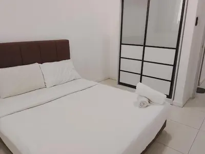 a white bed with a roll of toilet paper on it at Chamber Klcc Suites Luxury Home in Kuala Lumpur