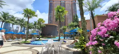 a hotel courtyard with a table and chairs and palm trees at Kuala Lumpur Service suite times square s in Kuala Lumpur