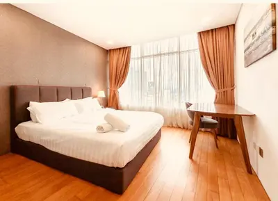 a bedroom with a bed and a desk and a window at Vortex Klcc By welcomes in Kuala Lumpur