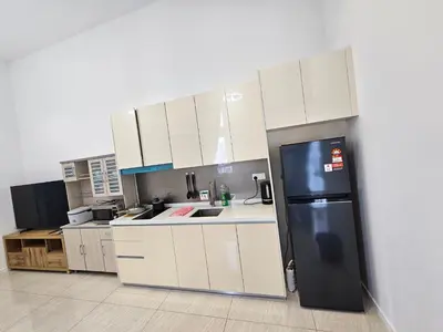 a kitchen with white cabinets and a black refrigerator at Presidential Suite Quill Residence KLCC in Kuala Lumpur