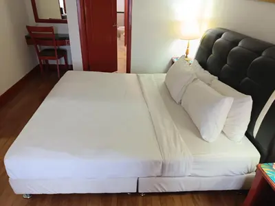 a white bed with a black headboard and white pillows at Berjaya Times Square KLCC by cozy stay in Kuala Lumpur