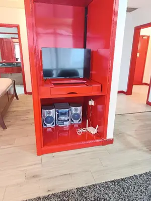 a red entertainment center with a flat screen tv at Berjaya Times Square KLCC by cozy stay in Kuala Lumpur