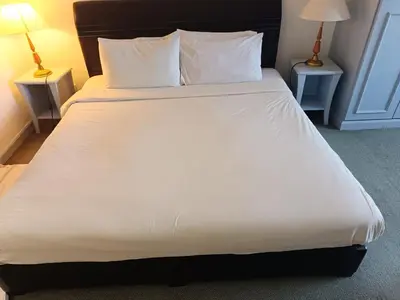 a bed with white sheets and pillows in a room at Berjaya Times Square KLCC by cozy stay in Kuala Lumpur