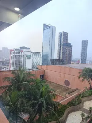 a view of a city from a building with palm trees at Berjaya Times Square KLCC by cozy stay in Kuala Lumpur
