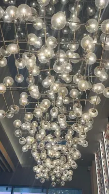 a bunch of chandeliers hanging from a ceiling at Majestic Suites KLCC by Aman Tokyo in Kuala Lumpur