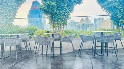 a group of chairs and tables on a patio at Majestic Suites KLCC by Aman Tokyo in Kuala Lumpur